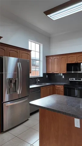 a kitchen with stainless steel appliances granite countertop a sink a stove and a refrigerator