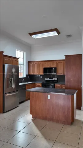 a kitchen with stainless steel appliances granite countertop a refrigerator and a stove