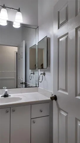 a bathroom with a sink a large mirror and a light fixture