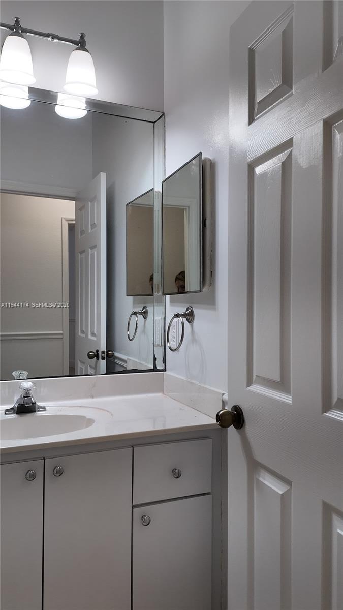 3265 Southwest 153rd Place Miami, FL 33185 - Photo 18 of 39 a bathroom with a sink a large mirror and a light fixture