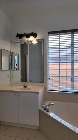 a bathroom with a tub a sink and a window