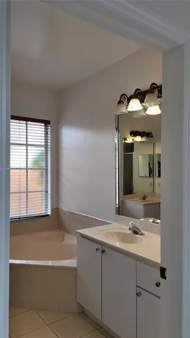 a bathroom with a tub sink and mirror