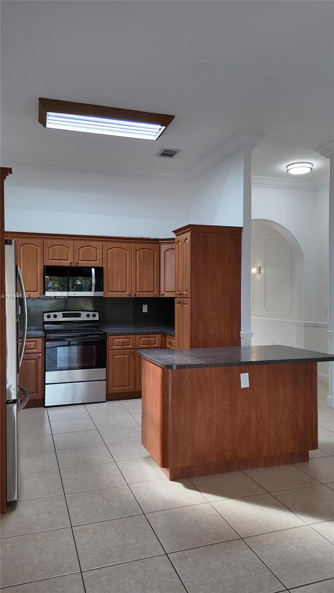 3265 Southwest 153rd Place Miami, FL 33185 - Photo 10 of 39 a kitchen with stainless steel appliances kitchen island granite countertop a stove and a sink