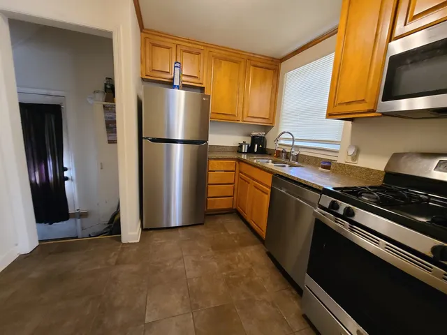 a kitchen with stainless steel appliances granite countertop a refrigerator stove and sink