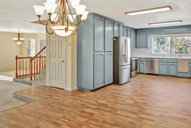 a kitchen with stainless steel appliances granite countertop a refrigerator and a sink