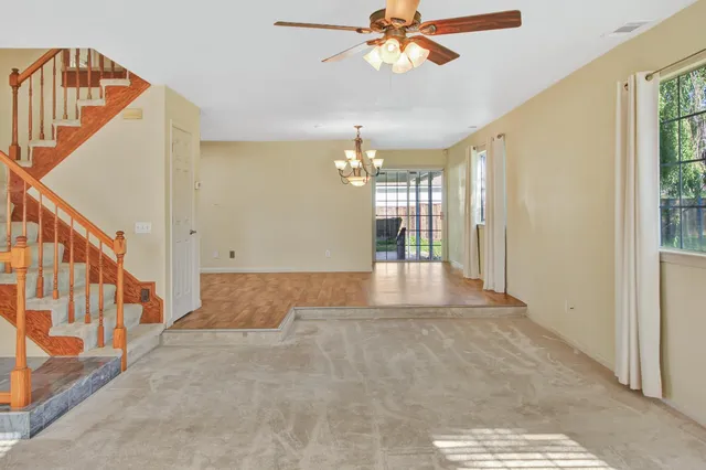 a kitchen with stainless steel appliances granite countertop a refrigerator a sink a stove and white cabinets