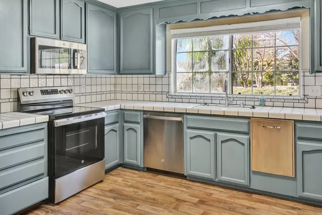 a view of a kitchen with a refrigerator and a chandelier