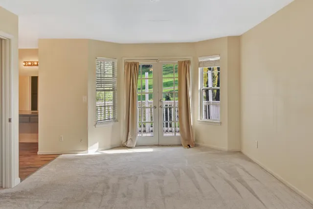a view of an empty room with window and closet area