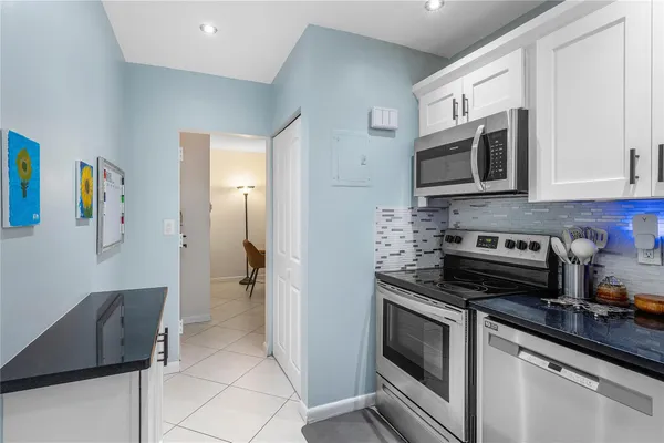a kitchen with stainless steel appliances granite countertop a refrigerator and a stove top oven