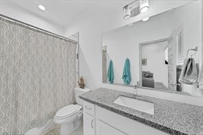 907 Frio Street Houston, TX 77012 - Photo 14 of 23 a bathroom with a granite countertop sink a toilet and a mirror