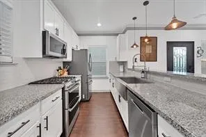 a large kitchen with granite countertop a sink and a stove