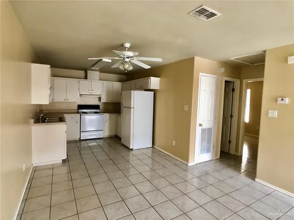 a kitchen with stainless steel appliances kitchen island granite countertop a refrigerator and a stove top oven