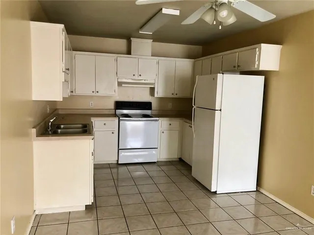 a kitchen with a refrigerator a stove a microwave and cabinets