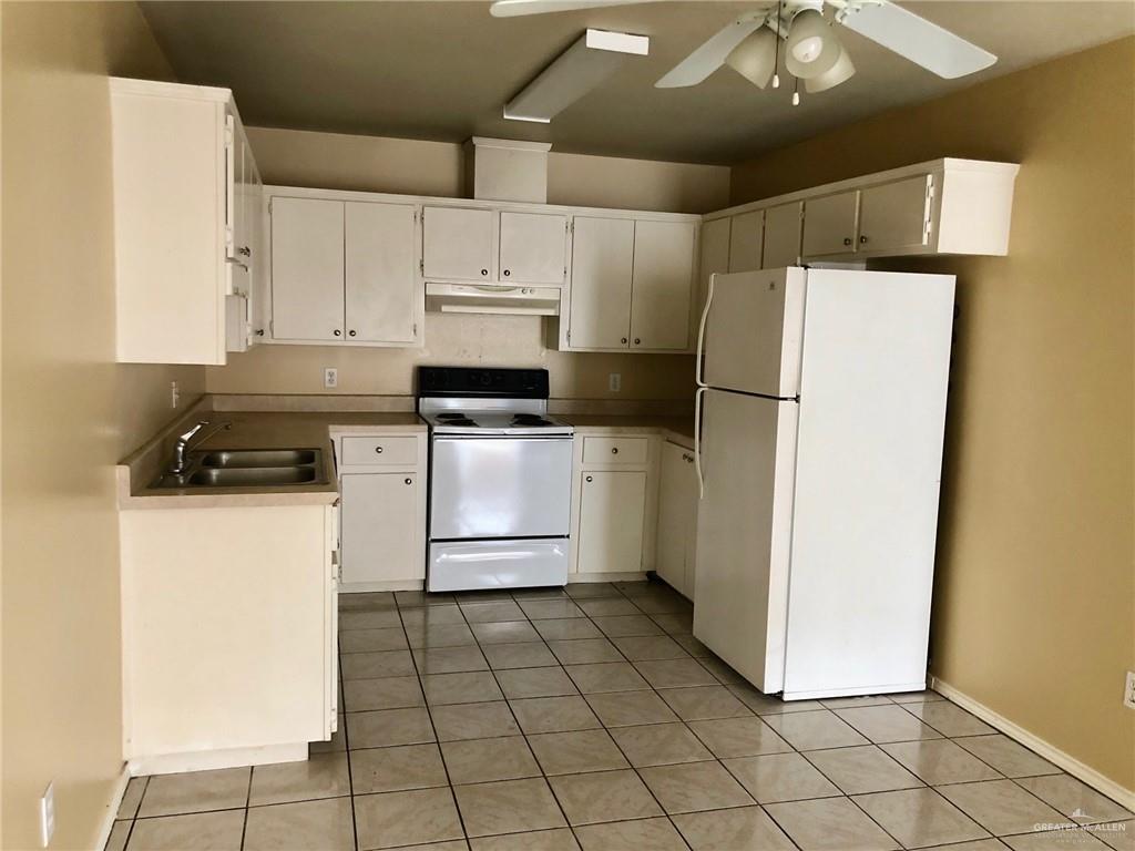 2508 East U.S. Business 83, Unit 27 Mission, TX 78572 - Photo 4 of 14 a kitchen with a refrigerator a stove a microwave and cabinets
