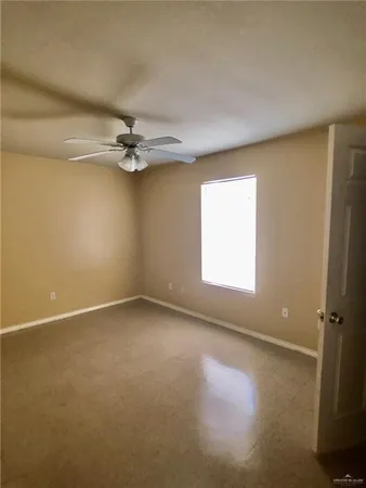 an empty room with windows and fan