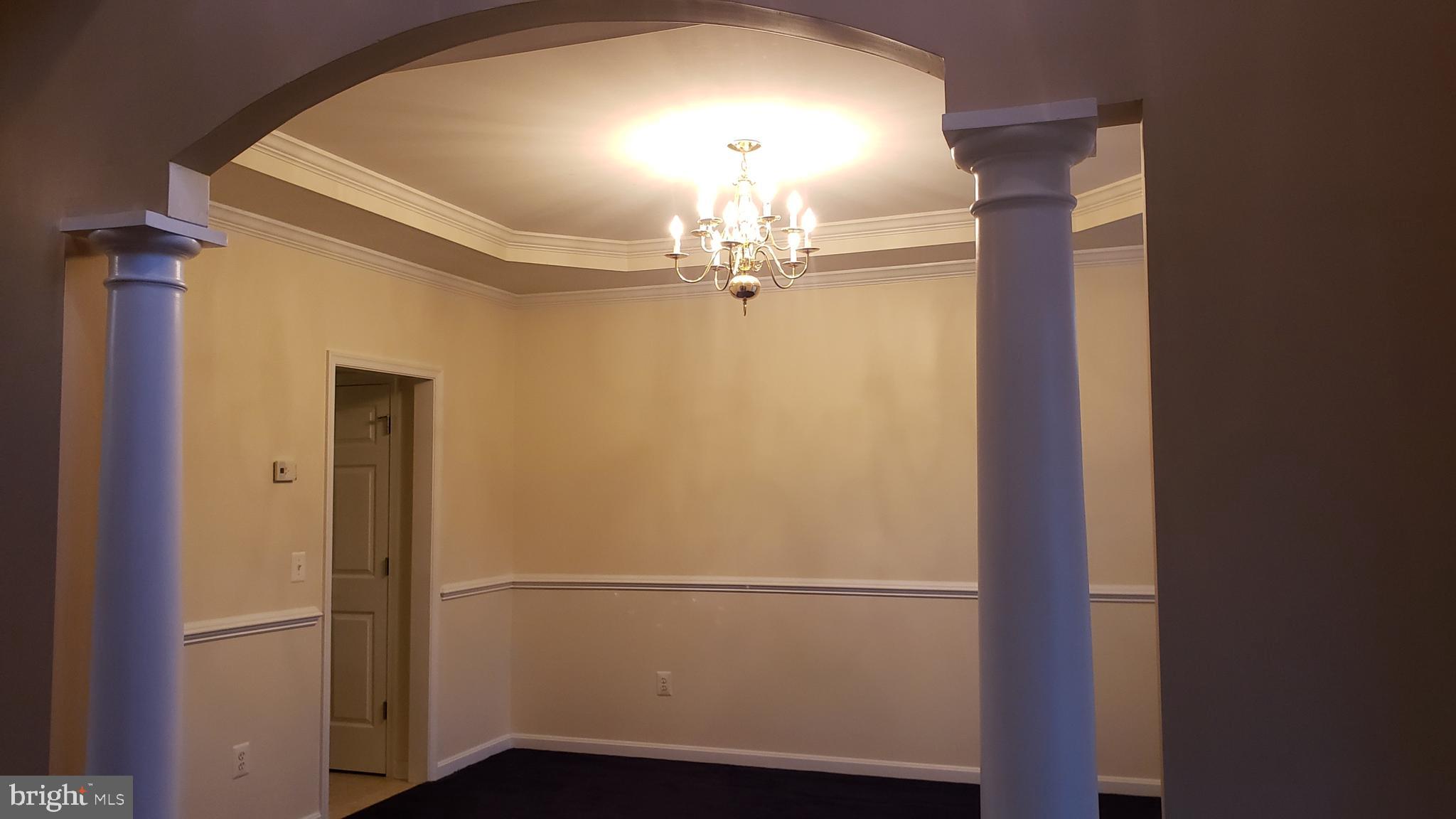 8637 Willow Run Road Baltimore, MD 21244 - Photo 14 of 56 a view of a hallway with wooden floor and chandelier