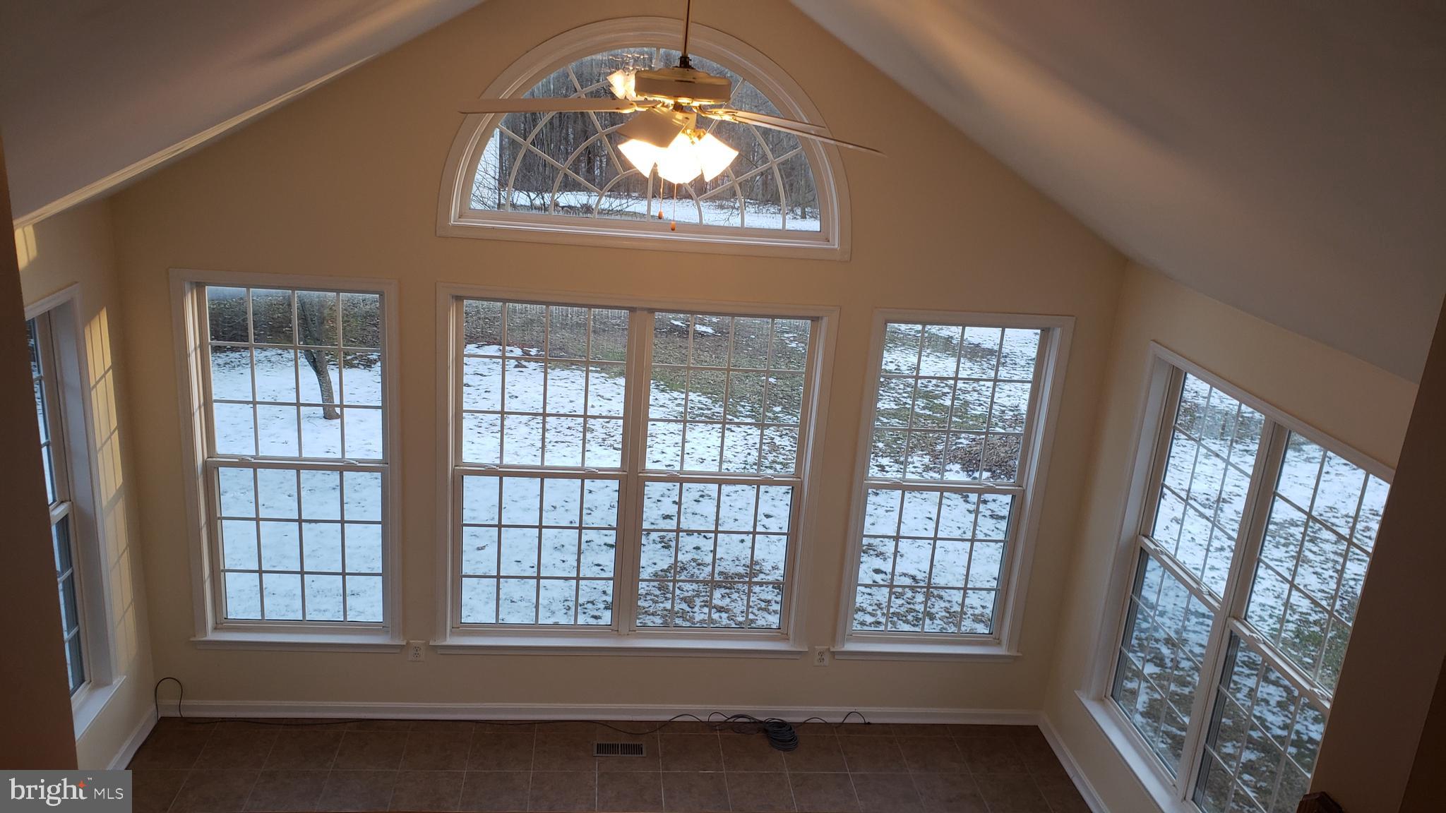 8637 Willow Run Road Baltimore, MD 21244 - Photo 29 of 56 an empty room with wooden floor fan and windows
