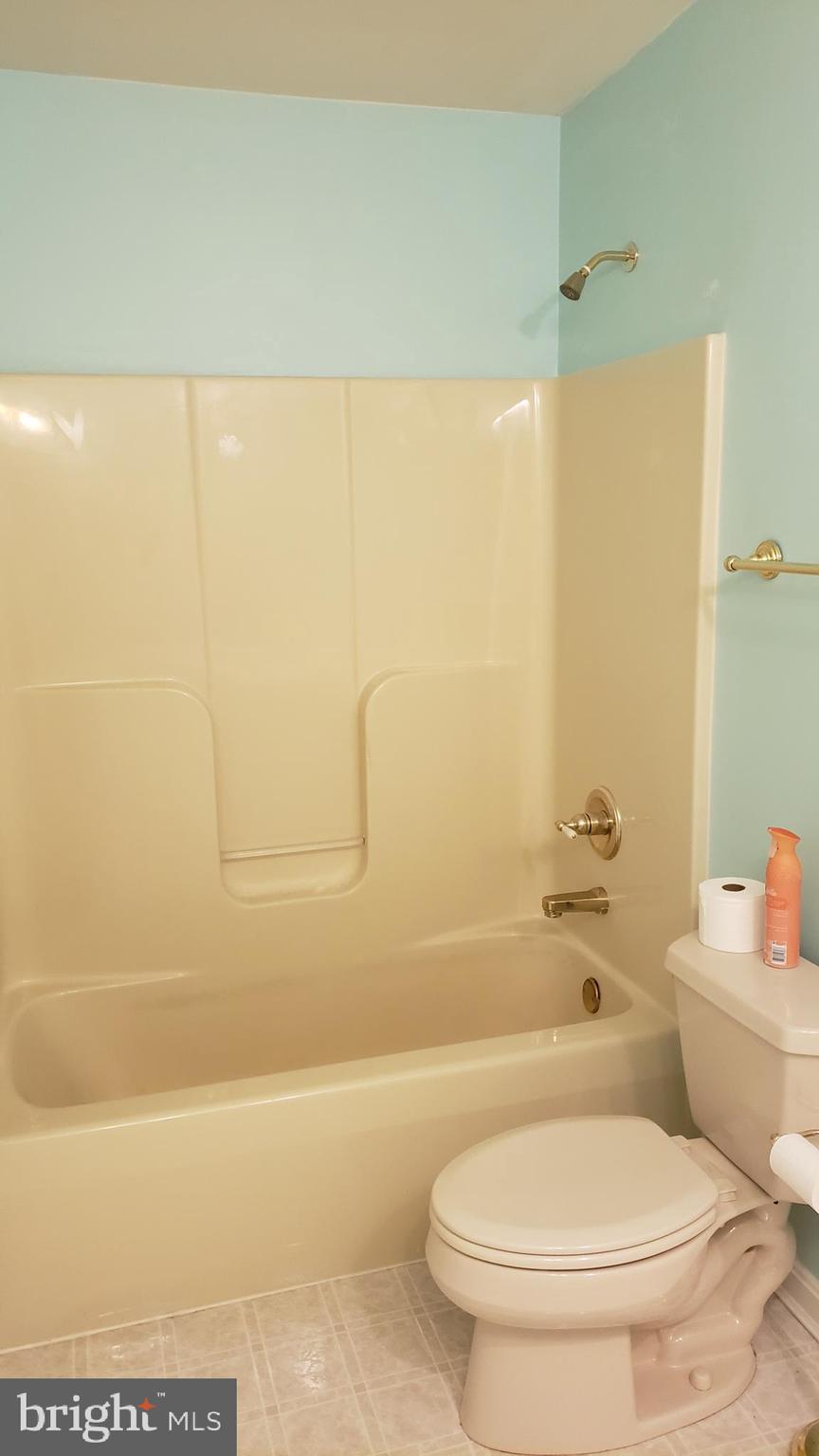 8637 Willow Run Road Baltimore, MD 21244 - Photo 39 of 56 a white toilet sitting next to a bath tub and a shower