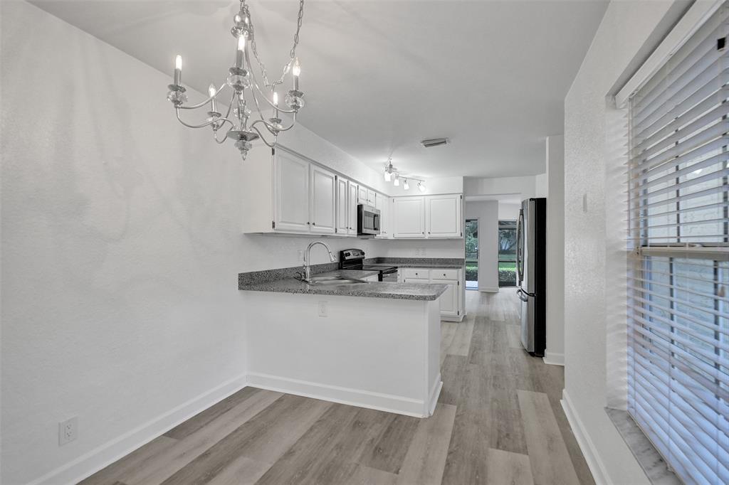 11652 Northwest 19th Drive Coral Springs, FL 33071 - Photo 16 of 52 a kitchen with kitchen island white cabinets and stainless steel appliances