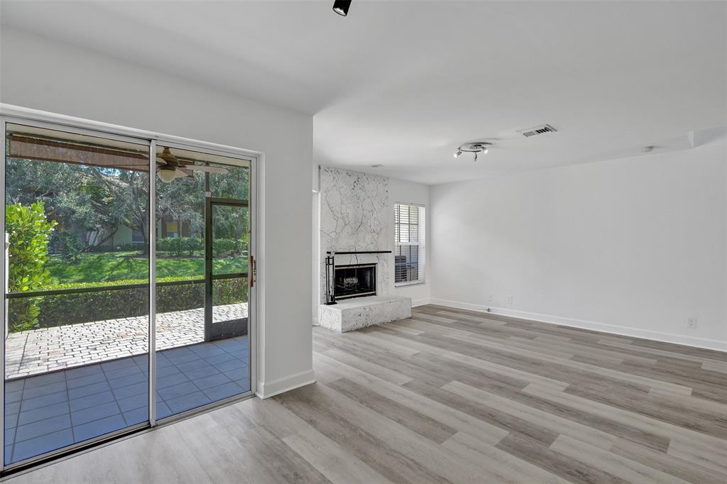 11652 Northwest 19th Drive Coral Springs, FL 33071 - Photo 10 of 52 a view of an empty room with wooden floor and a fireplace