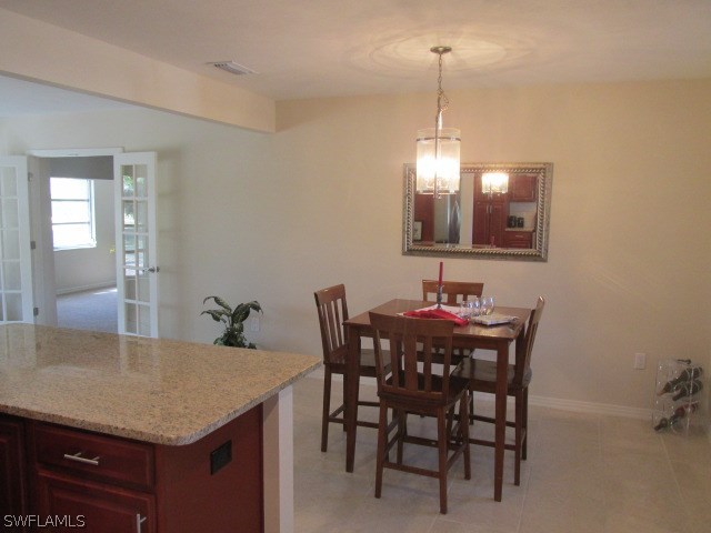4231 Ellis Road Fort Myers, FL 33905 - Photo 5 of 13 a view of a dining room and chairs and chandelier