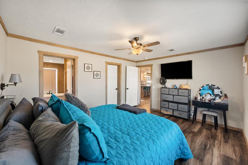 216 Southeast County Road Corsicana, TX 75109 - Photo 19 of 37 a spacious bedroom with a bed and a flat screen tv