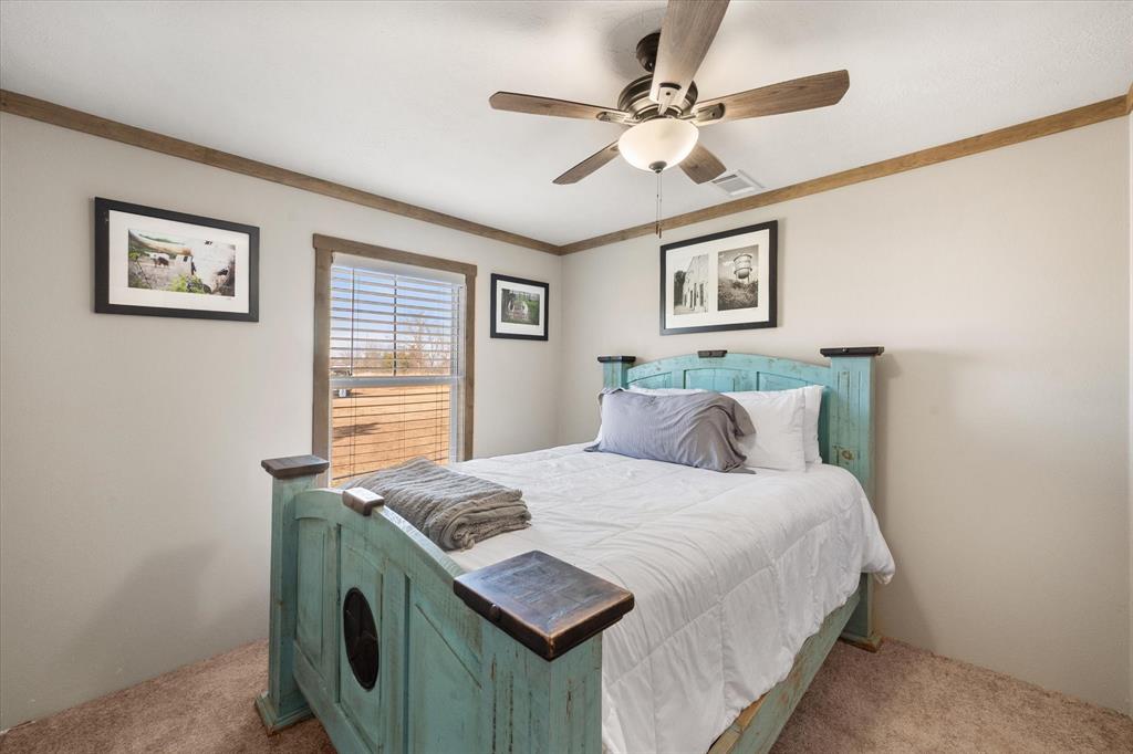 216 Southeast County Road Corsicana, TX 75109 - Photo 24 of 37 a bedroom with a bed and a chandelier