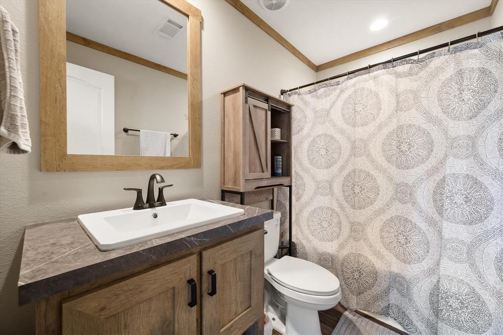 216 Southeast County Road Corsicana, TX 75109 - Photo 25 of 37 a bathroom with a sink toilet and a mirror