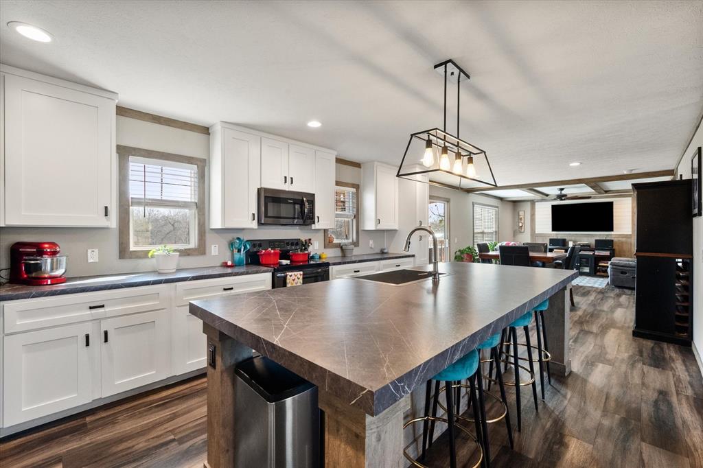216 Southeast County Road Corsicana, TX 75109 - Photo 6 of 37 a kitchen with sink a center island and appliances