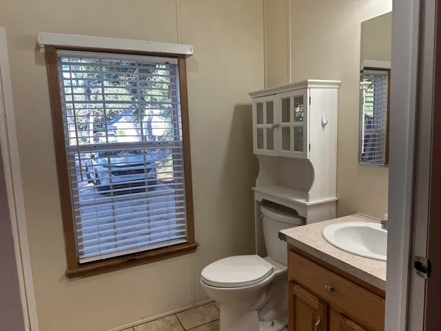 a bathroom with a sink a toilet a mirror and shower