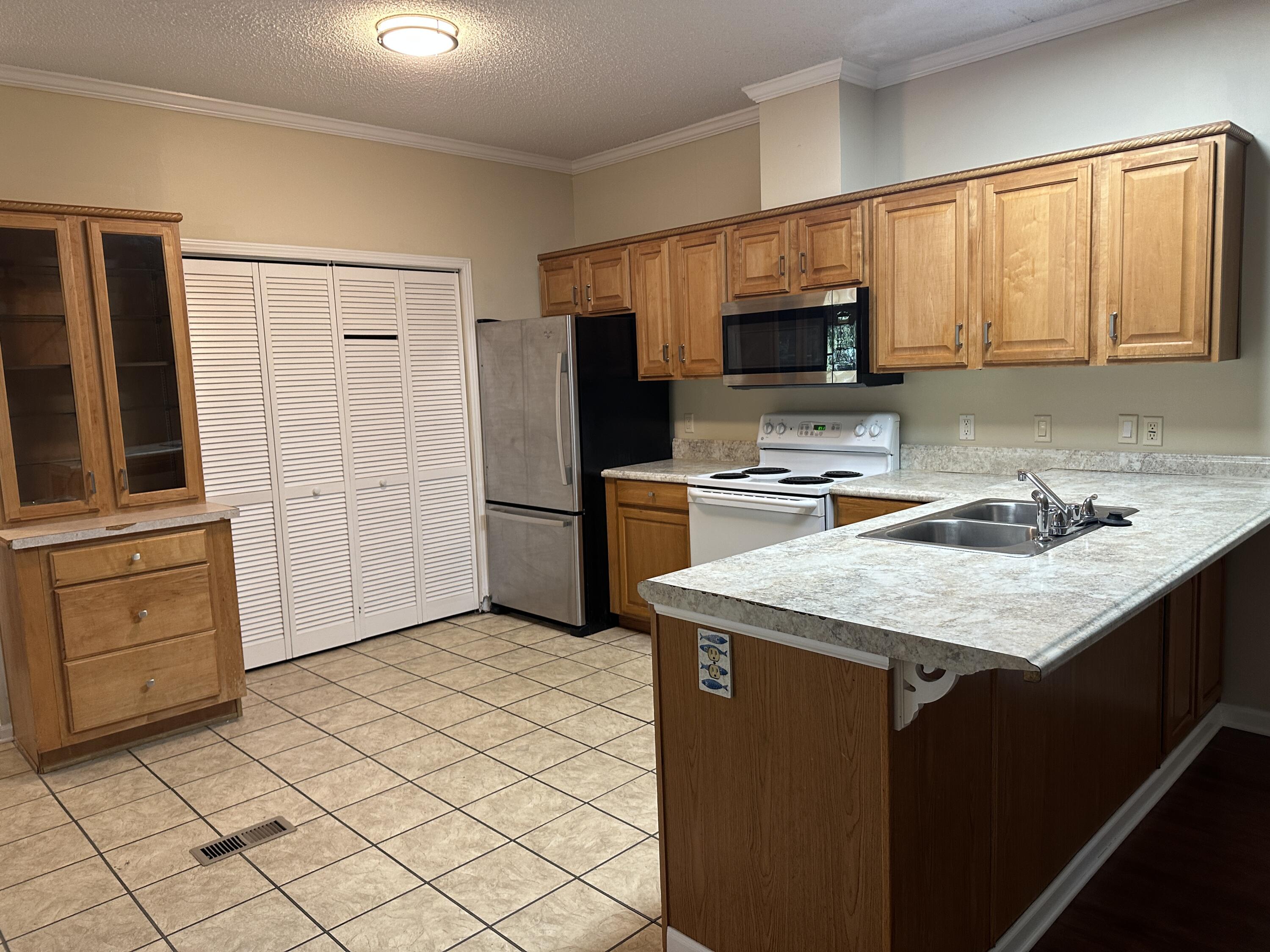 832 Cross Street, Unit A Destin, FL 32541 - Photo 8 of 15 a kitchen with a sink a stove a refrigerator and cabinets