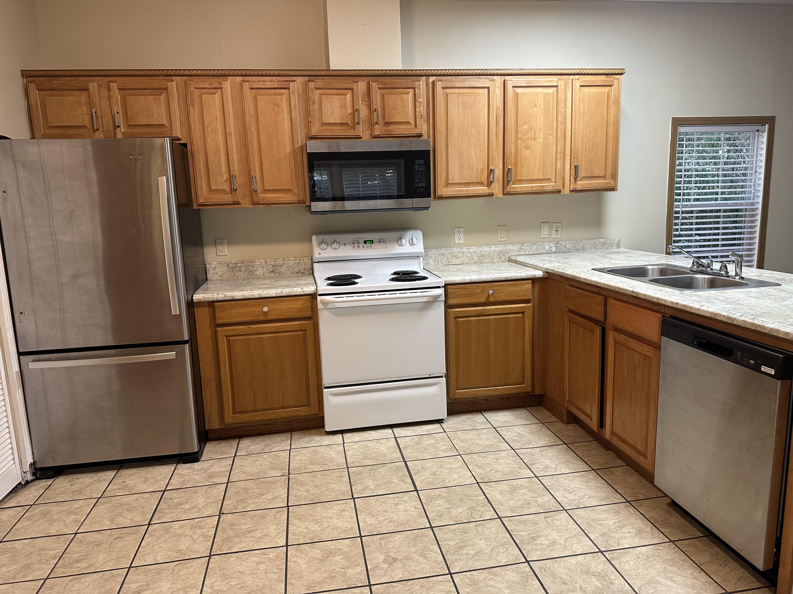 832 Cross Street, Unit A Destin, FL 32541 - Photo 10 of 15 a kitchen with a stove a sink and a refrigerator