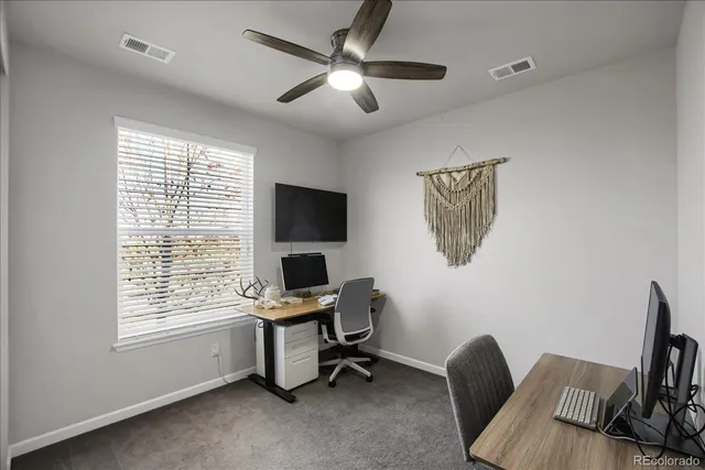 a view of a workspace with furniture and a window