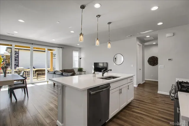 a large kitchen with kitchen island a island a sink a stove and wooden floor