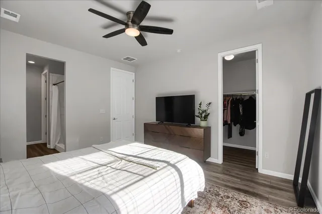 a bedroom with a bed and a flat tv screen on dresser