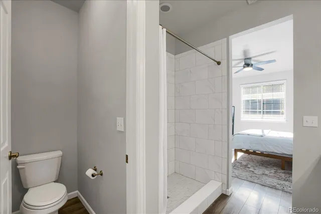 a bathroom with a granite countertop bathtub shower and toilet