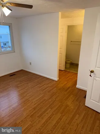 an empty room with wooden floor and a bathroom