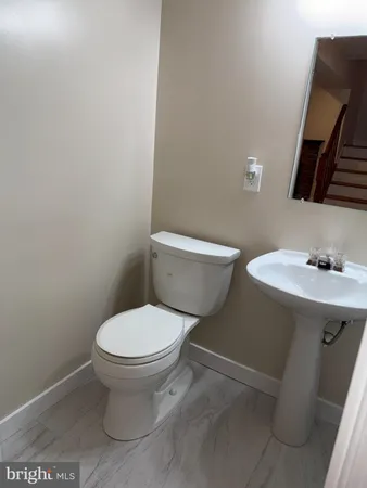 a white toilet sitting next to a bathroom sink