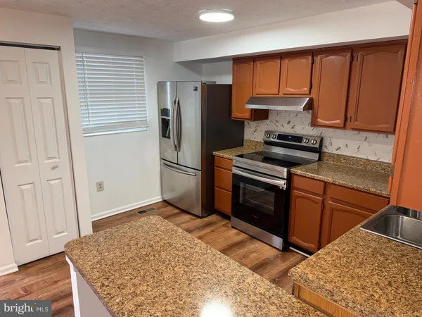 a kitchen with a stove a refrigerator and a sink
