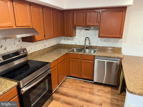 a kitchen with granite countertop a sink stove and cabinets
