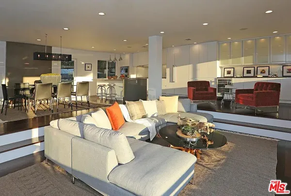 a living room with furniture kitchen view and a couch