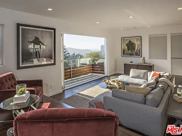 a living room with furniture and a floor to ceiling window