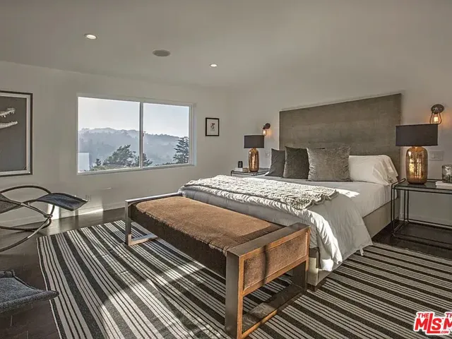 a bedroom with double bed and a large window