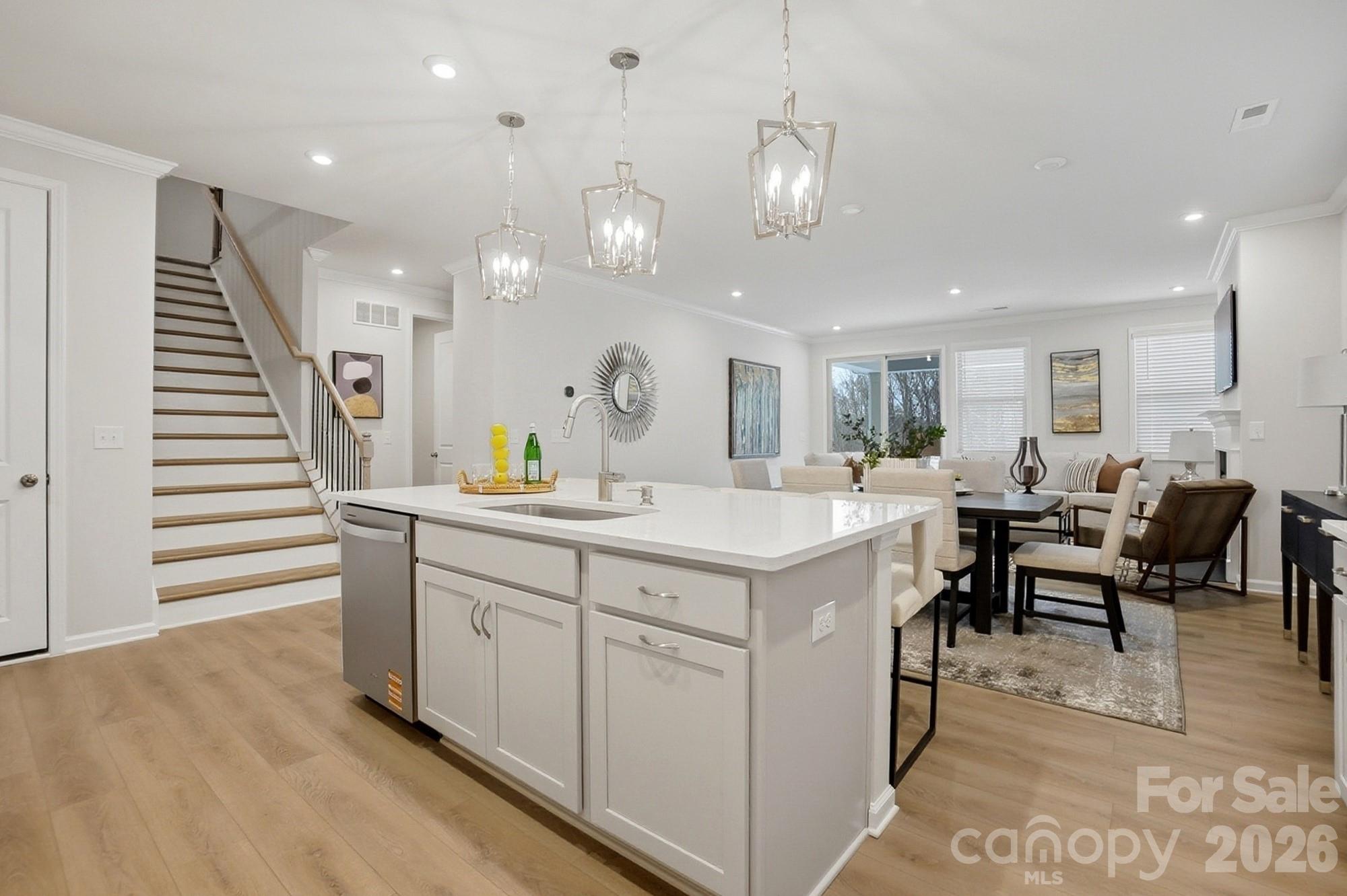 9931 Cask Way Huntersville, NC 28078 - Photo 11 of 42 an open kitchen with white cabinets and chandelier