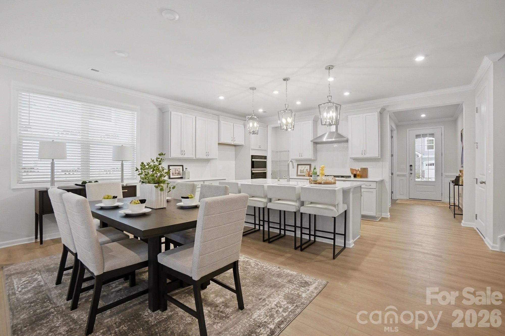 9931 Cask Way Huntersville, NC 28078 - Photo 13 of 42 a view of a dining room and livingroom with furniture wooden floor and a rug
