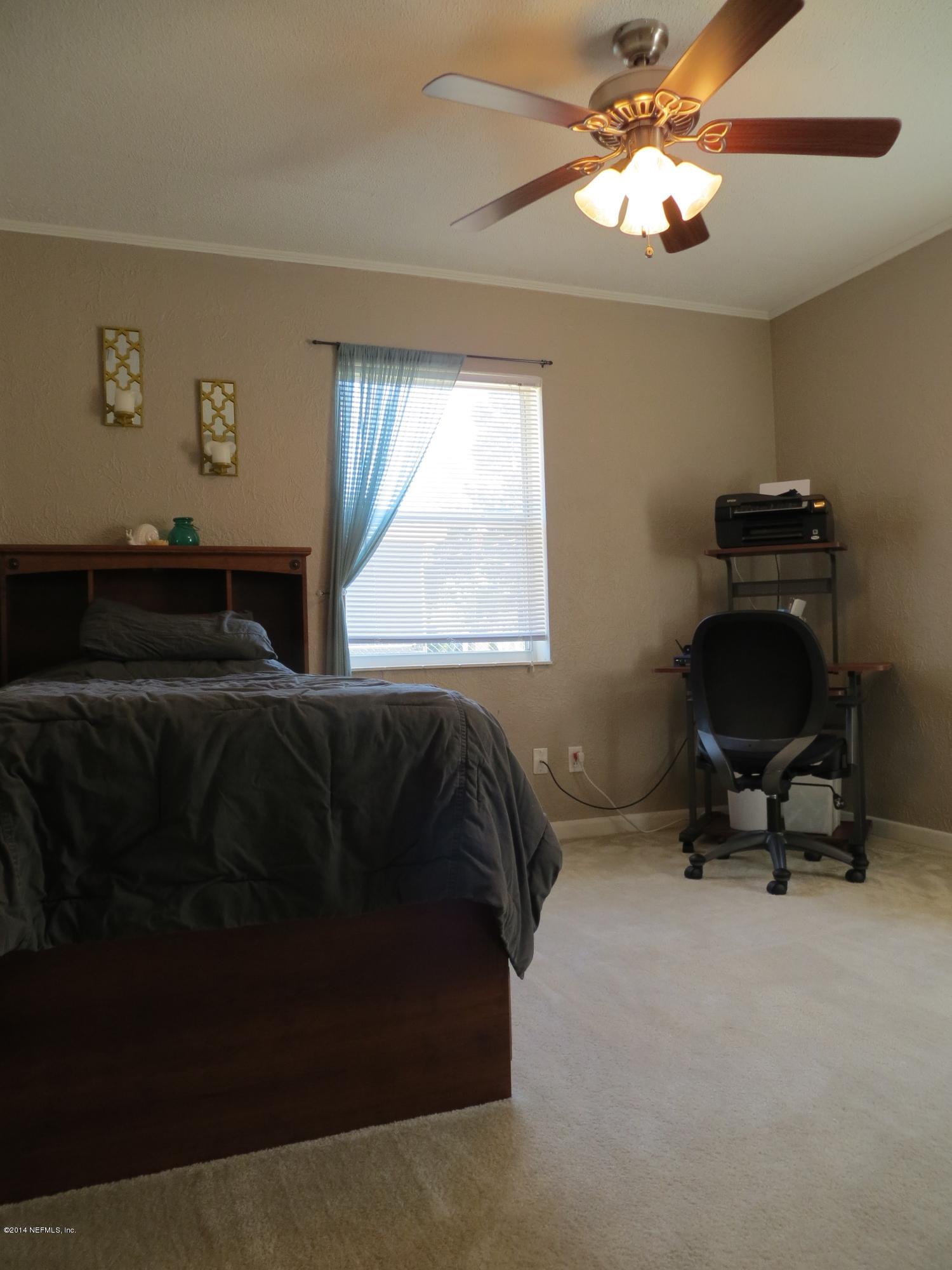 6025 Stetson Road Jacksonville, FL 32217 - Photo 6 of 13 a bedroom with a bed and a chandelier
