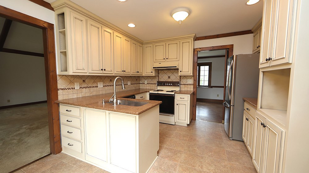 7009 Valley Drive Raleigh, NC 27612 - Photo 3 of 13 updated kitchen w/ granite counters, quality cabinetry, SS sink. and tile back splash. Kitchen