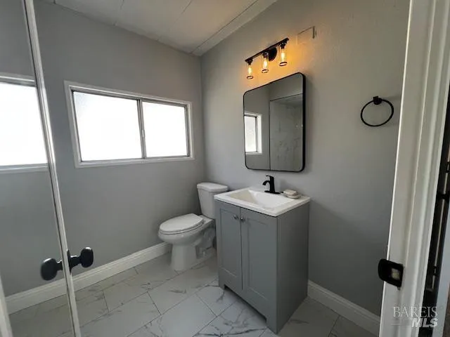 a bathroom with a toilet sink and mirror