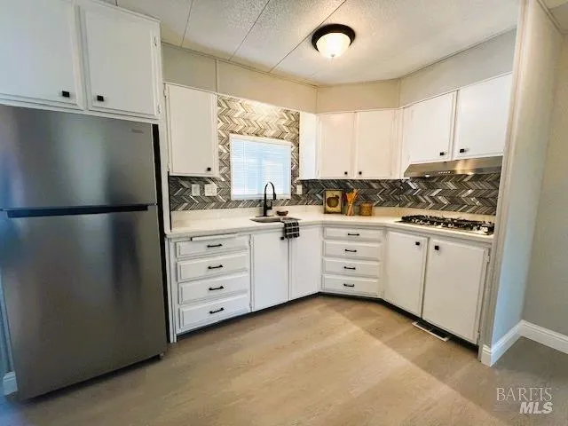 a kitchen with white cabinets white appliances and sink