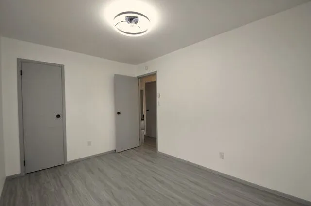 a view of an empty room with wooden floor